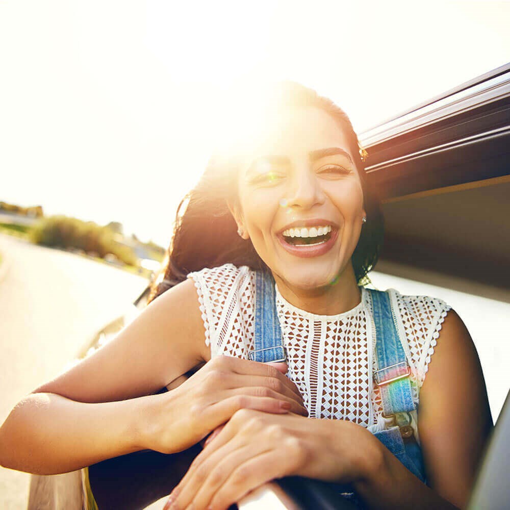 Young Woman Smiling Riding Car